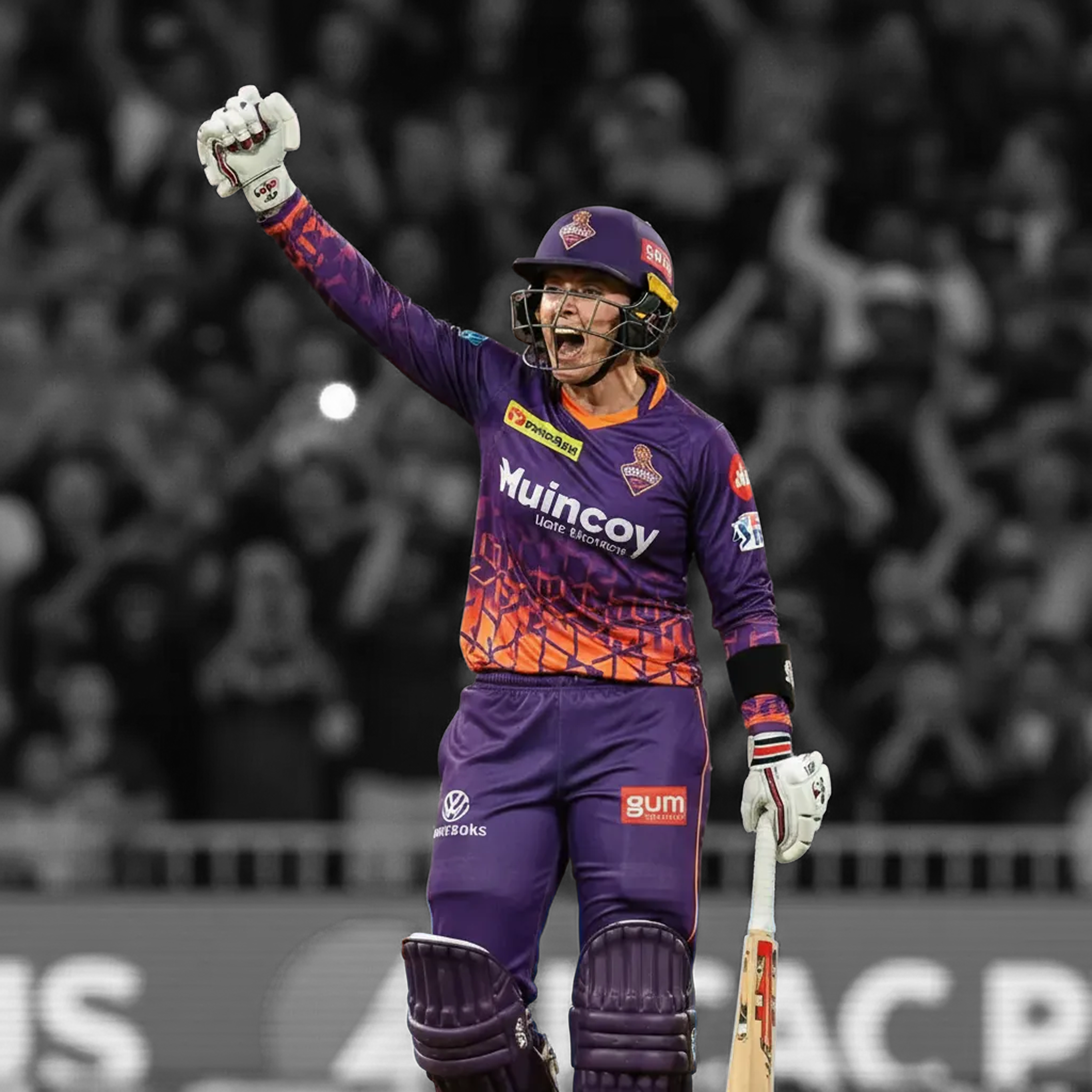 Female professional cricketer celebrating with fist raised in full stadium
